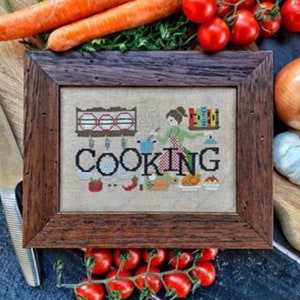 Peut inclure: Un motif de point de croix encadré avec le mot "COOKING" en grandes lettres. Le motif représente une femme cuisinant dans une cuisine avec une casserole, une étagère avec des plats et un livre de cuisine.