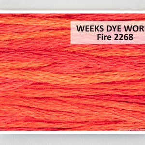 May include: Close-up of Weeks Dye Works embroidery floss in the color Fire 2268. The floss is a bright orange-red color.