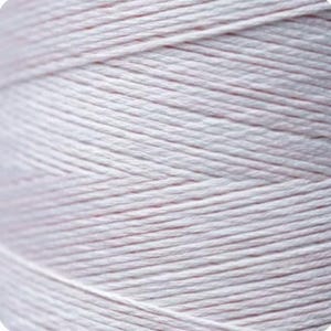 May include: Close-up of a spool of white cotton yarn.