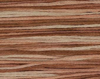 May include: Close-up of embroidery floss in shades of brown, tan, and peach. The threads are arranged horizontally, creating a textured, layered effect. Ideal for various craft projects, the floss offers a natural, earthy color palette.