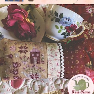 Può includere: Un cuscino per spilli da giardino da tè a punto croce con una piccola casa e un motivo floreale. Il cuscino è realizzato con Treenway Silks Tea Time Palette XStitch the Rainbow e progettato da Lori Pengelly.