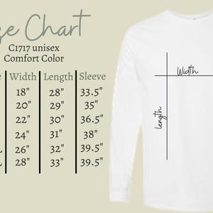 Op de afbeelding: Een wit shirt met lange mouwen met een maattabel. De tabel toont maten S tot 3XL, met bijbehorende afmetingen voor breedte, lengte en mouwlengte in inches. De afmetingen van het shirt worden aangegeven met lijnen.