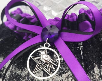 Liga de boda gótica: satén morado, encaje negro y dije de pentáculo de cuervo.