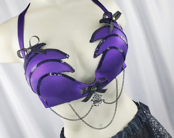 May include: Purple and black lingerie top with a rose design and chain accents.