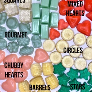 May include: Assortment of colorful handmade soap bars in various shapes, including squares, bricks, hearts, circles, barrels, and stars. The soap bars are arranged in groups by shape and color.