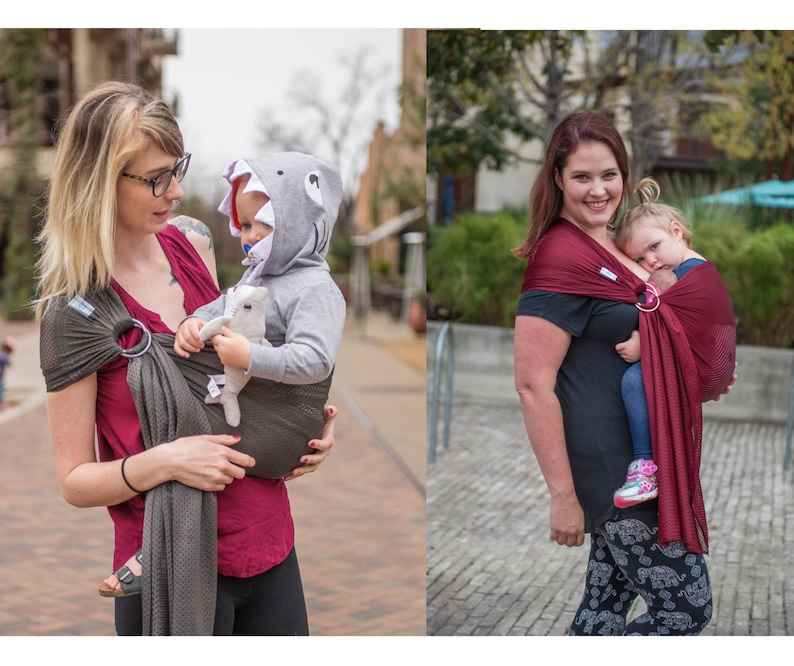 Puede incluir: Dos portabeb&eacute;s en uso. Uno es gris oscuro con un anillo plateado, el otro es burdeos con un anillo dorado. Ambos se utilizan para transportar a ni&ntilde;os peque&ntilde;os. El beb&eacute; del primer portabeb&eacute;s lleva una sudadera con capucha de tibur&oacute;n.