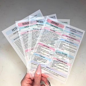 May include: A set of translucent, layered informational cards featuring biographical summaries of biblical figures including Esther, Moses, and Deborah. Each card contains printed text sections detailing name meanings, roles, life lessons, and historical facts.