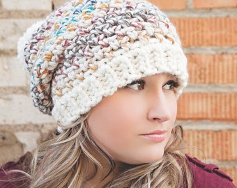 May include: A chunky knit beanie in cream and multicolored yarn. The hat features a wide, ribbed brim and a textured crown with flecks of blue, red, and yellow. A cozy winter accessory.