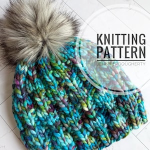 May include: A chunky knit beanie featuring a variegated yarn pattern in shades of teal, blue, green, and purple, topped with a large, fluffy faux fur pom-pom. The text KNITTING PATTERN JENNIFERDOUGHERTY is overlaid on the right side of the image.