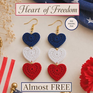 May include: A pair of patriotic crochet heart earrings in red, white, and blue. The earrings feature three stacked hearts in each color, connected by gold-colored beads and hooks. The image includes the text "Heart of Freedom" and "Almost FREE".