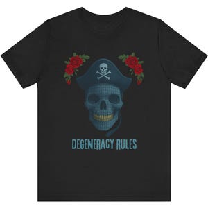 May include: Black t-shirt featuring a skull wearing a pirate hat with a skull and crossbones. The skull is blue and has a pattern. Red roses are on either side of the hat. The text "DEGENERACY RULES" is below the skull.