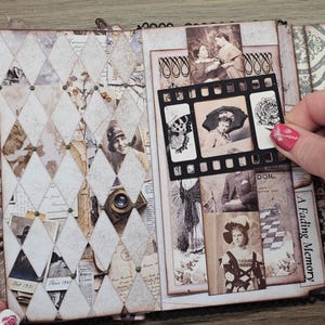 May include: Open scrapbook with vintage-style pages. The left side features a diamond pattern with old photos and ephemera. The right side displays more photos and the text "A Fading Memory." A film strip-shaped photo holder is being held.