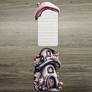 Tall floral mushroom cottage hidden note with the lined insert removed and displayed above the house design on a wooden background.