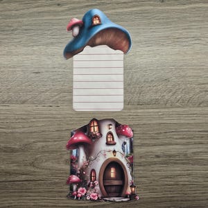 Blue mushroom cottage hidden note with the lined insert removed and displayed above the house design on a wooden background.