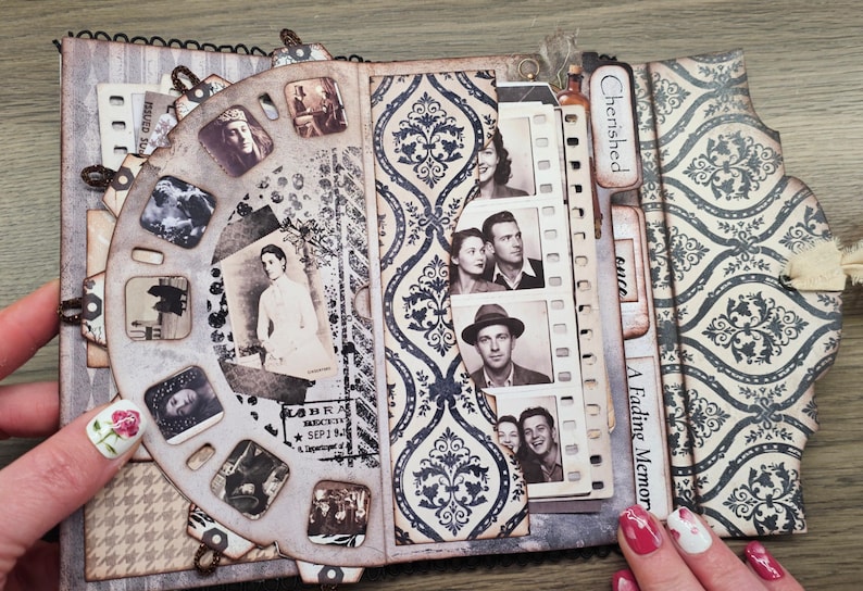 May include: A vintage-style scrapbook with a rotating viewer featuring small, square images. The scrapbook has pages with patterned designs and film strip-style photo holders. The cover is decorated with a damask pattern and the words "A Fading Memory".
