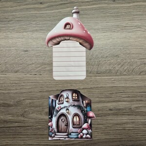 Pink mushroom cottage hidden note shown with the lined insert removed and displayed above the cottage house design on a wooden background.