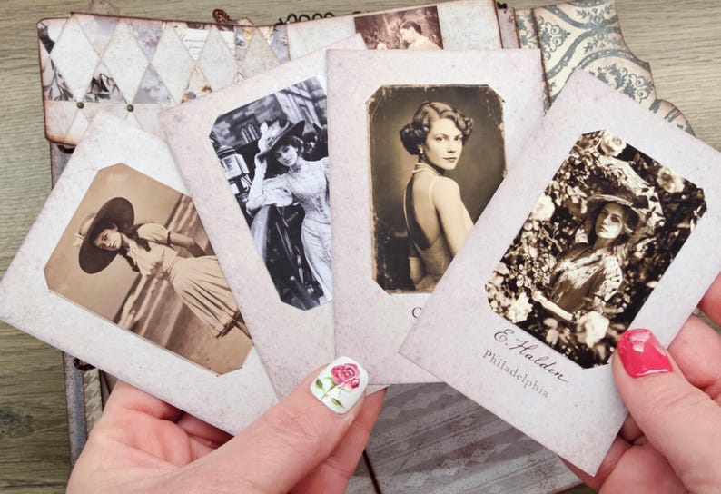 May include: A collection of vintage-style photographs featuring women in elegant attire. The sepia-toned images are held in a decorative album, showcasing a nostalgic aesthetic. One photo includes the text "E. Halden, Philadelphia."