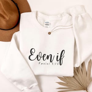 May include: White sweatshirt with the text "Even if" and "Daniel 3:18" in black lettering.