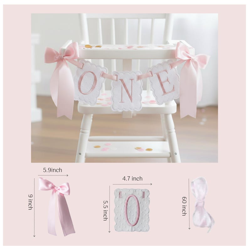 May include: A white high chair decorated with a pink "ONE" banner and pink bows. The banner is made of white scalloped squares with pink lettering. The bows are 9 inches long and 5.9 inches wide. The "0" banner is 5.5 inches tall and 4.7 inches wide.