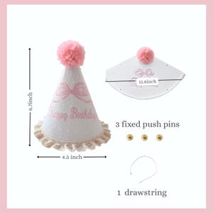 May include: White party hat with pink accents, a pink pom-pom, and a lace trim. The hat has a pink bow design and the words "Happy Birthday". The hat is 6.7 inches tall and 4.5 inches wide.