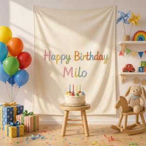 Può includere: Uno sfondo in tessuto color crema con il testo Happy Birthday Milo in lettere multicolori. Una torta bianca con cinque candeline è appoggiata su uno sgabello di legno. Palloncini colorati, regali incartati e un coniglio di peluche a dondolo.