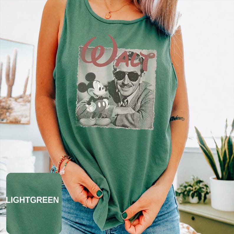 Peut inclure: Un d&eacute;bardeur vert clair sans manches avec une impression graphique de Walt Disney portant des lunettes de soleil &agrave; c&ocirc;t&eacute; de Mickey Mouse. Le mot Walt est imprim&eacute; dans une grande police stylis&eacute;e au-dessus de l'image en noir et blanc.