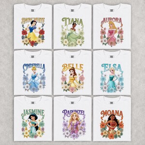 Puede incluir: Nueve camisetas blancas con princesas Disney: Blancanieves, Tiana, Aurora, Cenicienta, Bella, Elsa, Jasmine, Rapunzel y Moana. Cada camiseta muestra el nombre y la imagen de una princesa rodeada de dise&ntilde;os florales.