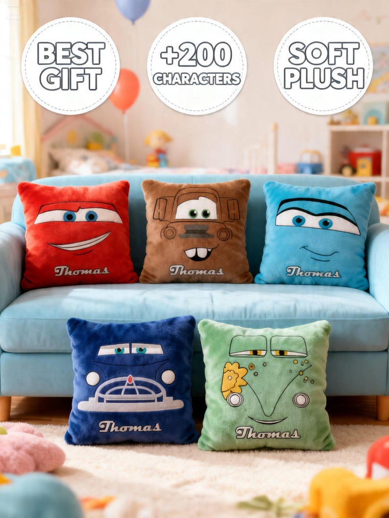 May include: Five plush character pillows in red, brown, blue, dark blue, and green, each with a different cartoon car face. The pillows are on a light blue couch. Each pillow has the name "Thomas" embroidered on it.