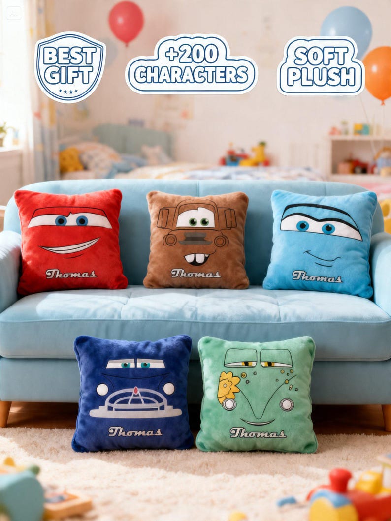 May include: Five plush square pillows with car-themed designs in red, brown, blue, dark blue, and green. Each pillow features a car face and the name "Thomas" below. The pillows are on a light blue couch.