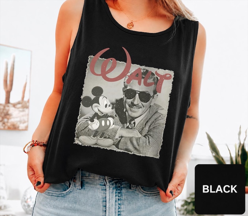 Peut inclure: Un d&eacute;bardeur noir sans manches avec une impression graphique de Walt Disney et Mickey Mouse dans un style vintage en noir et blanc. Le mot Walt est imprim&eacute; dans une grande police cursive rose poudr&eacute; au-dessus de l'image. Col rond.