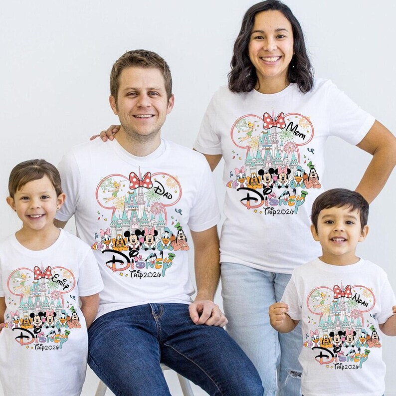 May include: White t-shirts with a Disney theme, featuring a castle design, Mickey Mouse, and other characters. The shirts have the text "Dad", "Mom", "Emily", and "Noah", along with "Disney Trip 2026". The family is smiling.