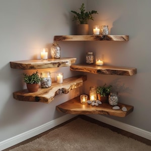 Pode incluir: Prateleiras flutuantes de madeira instaladas em um canto, com um design de borda natural. Cada prateleira contém itens decorativos como plantas em vasos, potes de vidro cheios de pedras e velas acesas, criando um ambiente acolhedor. As prateleiras são montadas em uma parede de cor neutra.