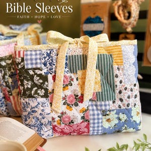 May include: A quilted fabric Bible sleeve featuring a patchwork design of various floral, gingham, and striped patterns in shades of blue, yellow, pink, and green. The rectangular cover includes a yellow floral fabric tie closure at the top center.