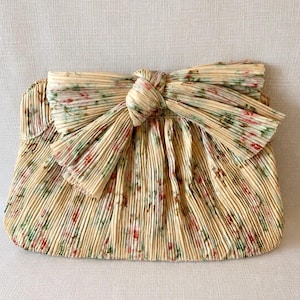 Front view of Loeffler Randall Rayne floral pleated bow clutch in tan vine print with structured frame shape.