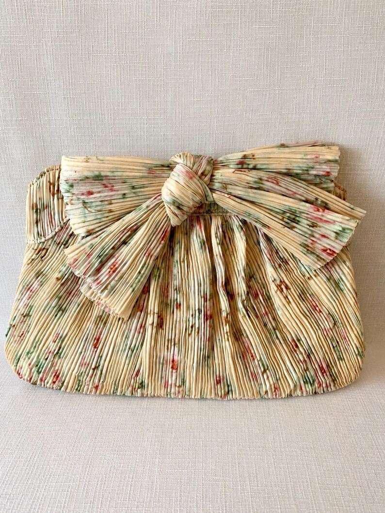 Front view of Loeffler Randall Rayne floral pleated bow clutch in tan vine print with structured frame shape.