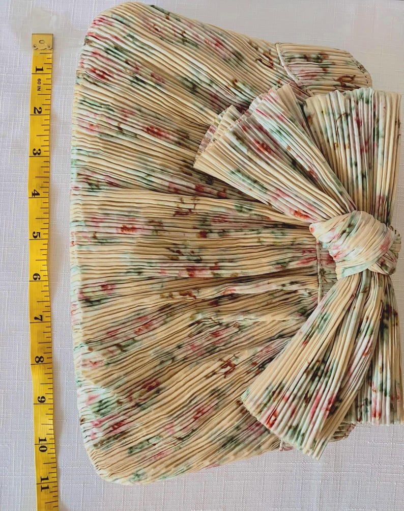 Measurement photo showing Loeffler Randall Rayne clutch height with tape measure, approximately 7 inches tall.
