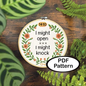 Op de afbeelding: Een kruissteekpatroon in een houten hoepel met de tekst "I might open, I might knock." Het ontwerp bevat bloemaccenten en het nummer "1410." Een label "PDF Pattern" staat rechtsonder.