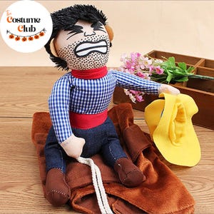 May include: A plush costume depicting a person riding a bucking bronco. The costume features a blue and white checkered shirt, denim pants, and brown boots. A yellow hat sits nearby. The Costume Club logo is in the upper left corner.
