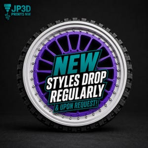 May include: A 3D-printed motorcycle wheel with a white rim, purple spokes, and a black tire. The wheel features the text "NEW STYLES DROP REGULARLY & UPON REQUEST!" in a teal and white banner. The JP3D PRINTS NW logo is in the upper left corner.