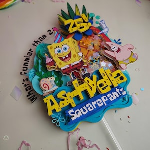 May include: A multi-layered cake topper featuring SpongeBob SquarePants, Patrick Star, and Gary the Snail. The design includes a shaker element with colourful beads, a pineapple, and the text "What's funnier than 25!" and "Ashlydia Squarepants."