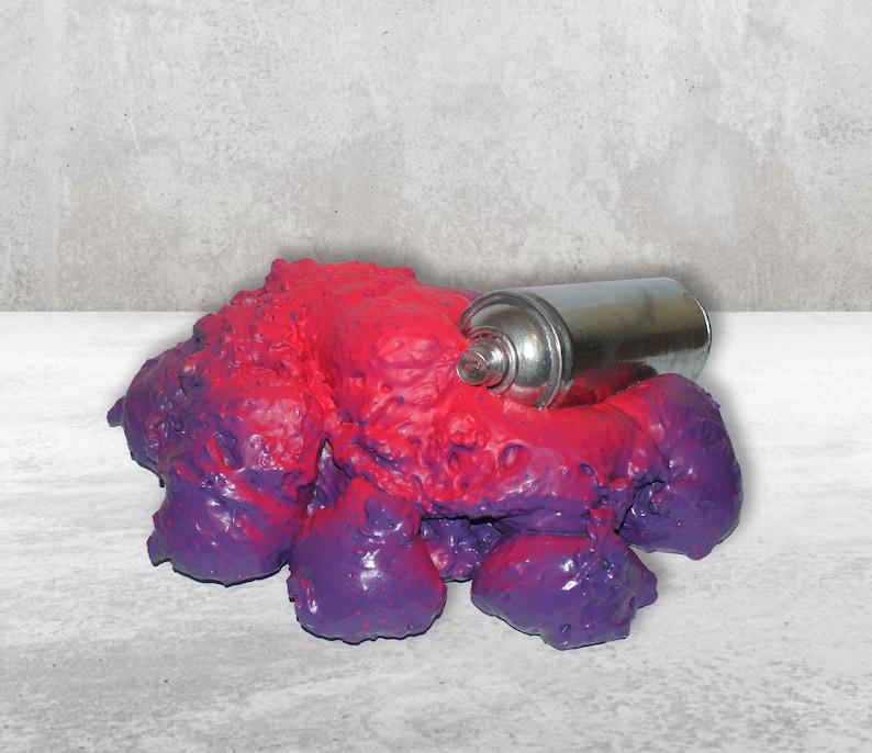 May include: A purple and red slime-like substance with a silver spray paint can partially submerged in it.