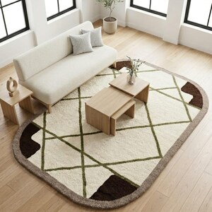 May include: An overhead shot of a modern living room with a cream-colored sofa, two small wooden side tables, and a geometric rug. The rug has a cream background with green and brown geometric patterns. The room has large windows and a small potted tree.