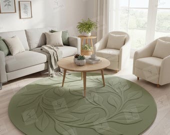 May include: A round, sage green rug with a raised leaf design in a living room setting. The rug is centered in front of a light-colored sofa and two armchairs. A wooden coffee table and side table with plants are also visible.