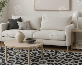 Pode incluir: Uma sala de estar em tons neutros com um sofá creme, almofadas cinzentas e uma mesa de centro redonda de madeira. Um tapete com um padrão de leopardo preto e cinzento cobre o chão. Uma obra de arte emoldurada está pendurada na parede.