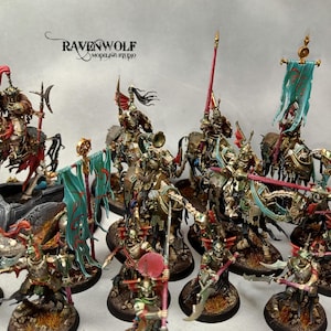 Puede incluir: Colección de figuras en miniatura pintadas con detalle, que representan caballeros montados y soldados de infantería. Los caballeros están a caballo y los soldados a pie, todos con armaduras detalladas, armas y estandartes. La paleta de colores incluye oro, rojo y turquesa.