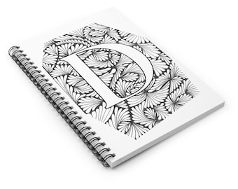 Könnte beinhalten: Ein weißes Notizbuch mit Spiralbindung, das einen großen, stilisierten weißen Buchstaben "D" zeigt. Der Buchstabe ist vor einem detaillierten schwarz-weißen Blumenmuster platziert. Das Notizbuch ist angewinkelt, wodurch die Spiralbindung sichtbar wird.