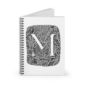 May include: A white spiral-bound notebook featuring a large letter "M" in white. The letter is set against a black and white leaf pattern. The notebook's pages are visible at the top.