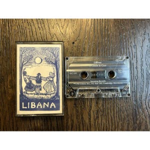 May include: A clear cassette tape with the album title "A Circle Is Cast" by Libana. The cassette case has a blue and white cover with the band's name and a graphic of three figures dancing under a tree.