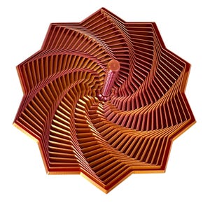 May include: A geometric wooden sculpture with a star-like shape. The sculpture features layers of reddish-brown wood, creating a spiral effect. A central, cylindrical element extends from the center. The artwork is set against a white background.