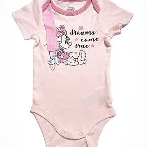 May include: Pink baby onesie with a Minnie Mouse graphic and the text "dreams come true".
